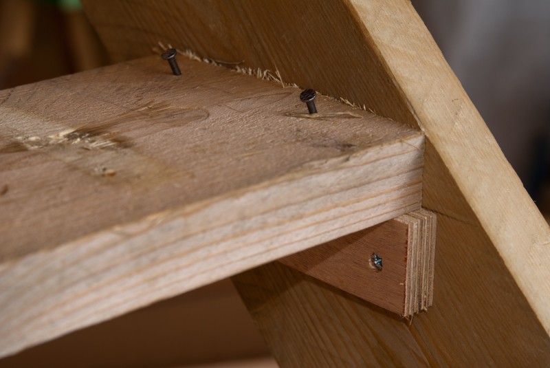 Zo ziet de bevestiging van een trede er uit: een balkje ter ondersteuning en twee schuin geslagen nagels om de trede op haar plaats te houden.