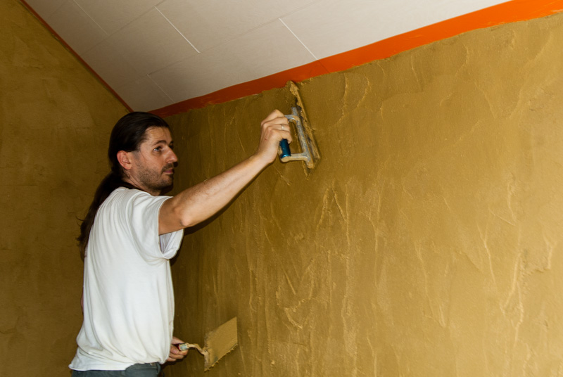 Nog één keer uitstrijken en onze eerste muur is bezet met een tweede laag leem.