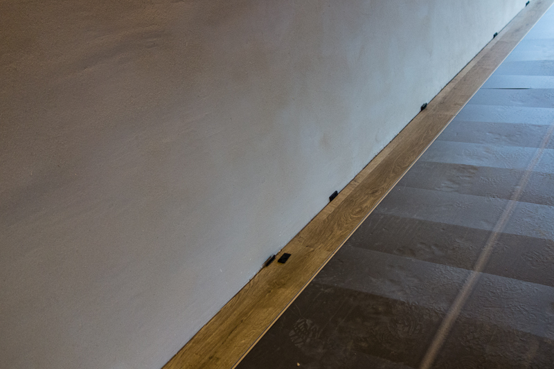 We legggen naast de smalle strook tegen de muur meteen ook de eerstvolgende volledige rij laminaat. Zo zijn we zeker dat we mooi recht en evenwijdig met de muur blijven.