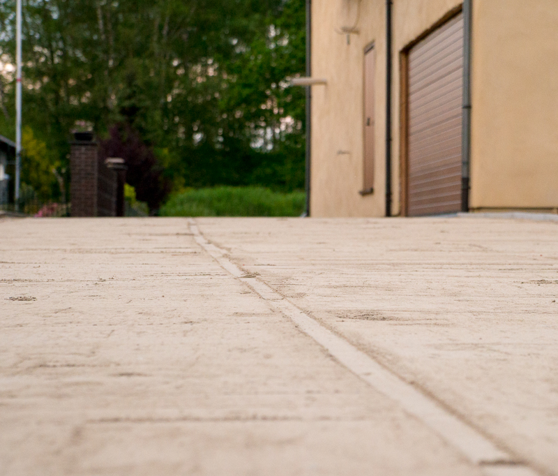 De oprit gezien vanaf de straat. Je ziet mooi de groef die de geleidingplank achtergelaten heeft in de stabilisé.