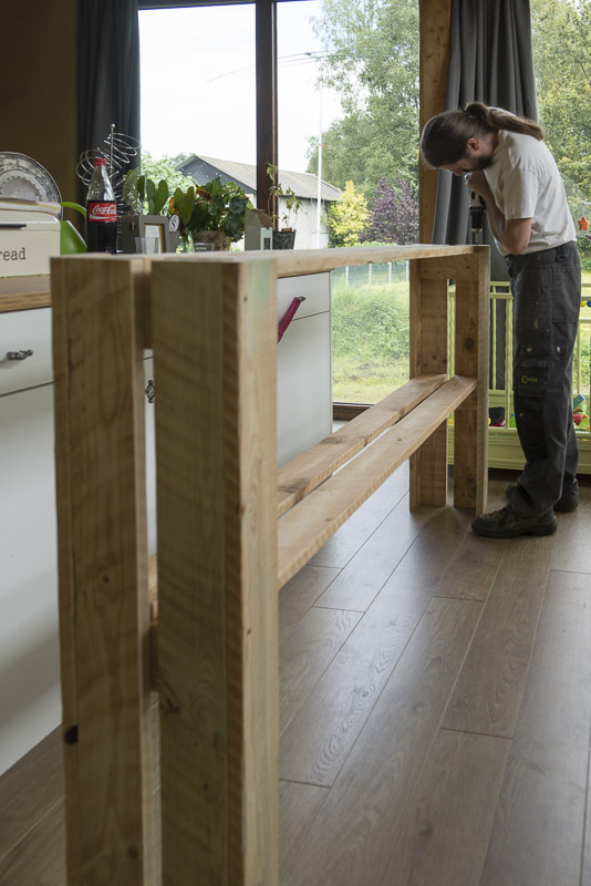 De lange planken worden vastgezet aan de zijkanten met schroeven en het plantenrekje krijgt al aardig vorm.