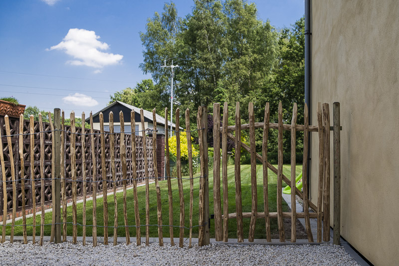 De omheining aan de linkerkant van het huis, inclusief poortje.