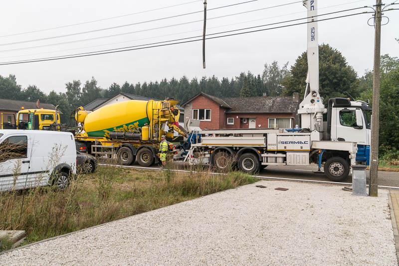 Omdat de betonmixer niet tot voor de garage kan rijden, is er ook een betonpomp nodig om de beton uit de mixer tot aan de garage te pompen.