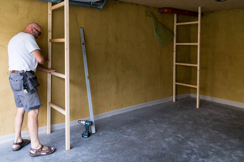 De ladders worden met de waterpas recht gezet en in het plafond vastgeschroefd.